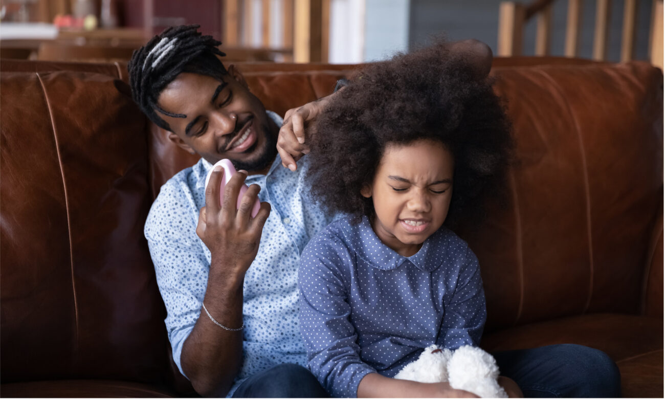 Father making hair of daugther